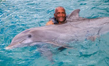 Jamaican swimming with Dolphin