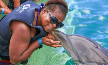 Lady getting kissed by Dolphin