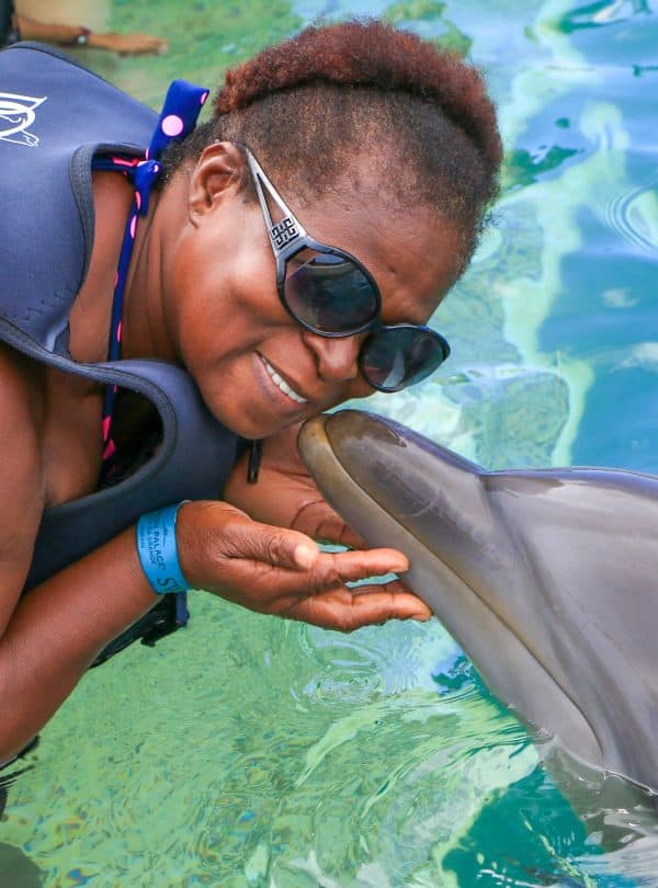 Lady getting kissed by Dolphin